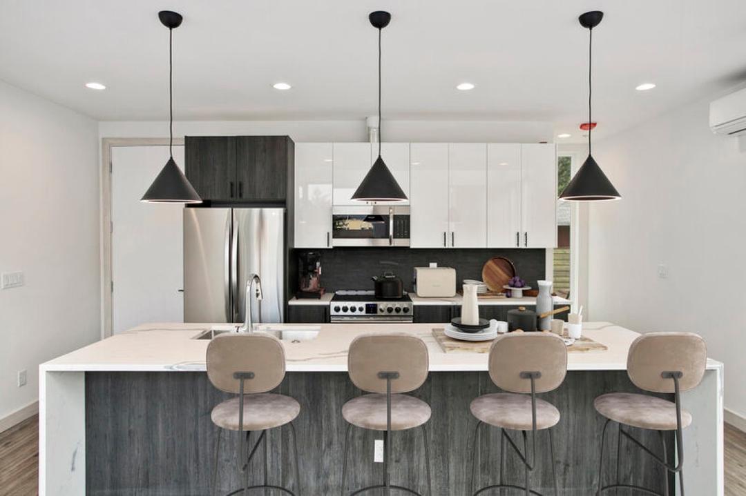 Virtually staged kitchen with an island, bar stools and pendant lighting